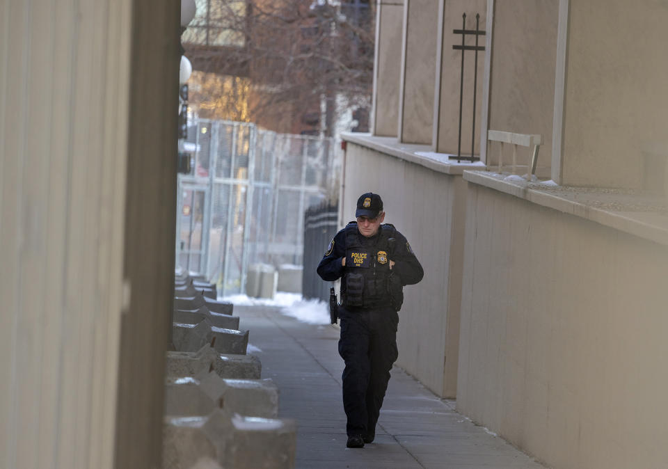 A security officer patrols the gated Warren E. Burger Federal Building as jury selection begins in the trial of ex-Minneapolis officers charged in the George Floyd killing in St. Paul, Minn., Thursday, Jan. 20, 2021. Jury selection began Thursday in the federal trial of three Minneapolis police officers charged in George Floyd’s killing, with the judge stressing repeatedly that fellow Officer Derek Chauvin's conviction on state murder charges and guilty plea to a federal civil rights violation should not influence the proceedings. (Elizabeth Flores/Star Tribune via AP)