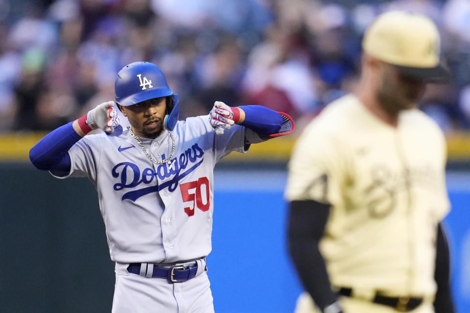 Los Angeles Dodgers' Mookie Betts (50) celebrates after his double as Arizona Diamondbacks first baseman Christian Walker, right, walks past during the first inning of a baseball game Friday, April 7, 2023, in Phoenix. (AP Photo/Ross D. Franklin)