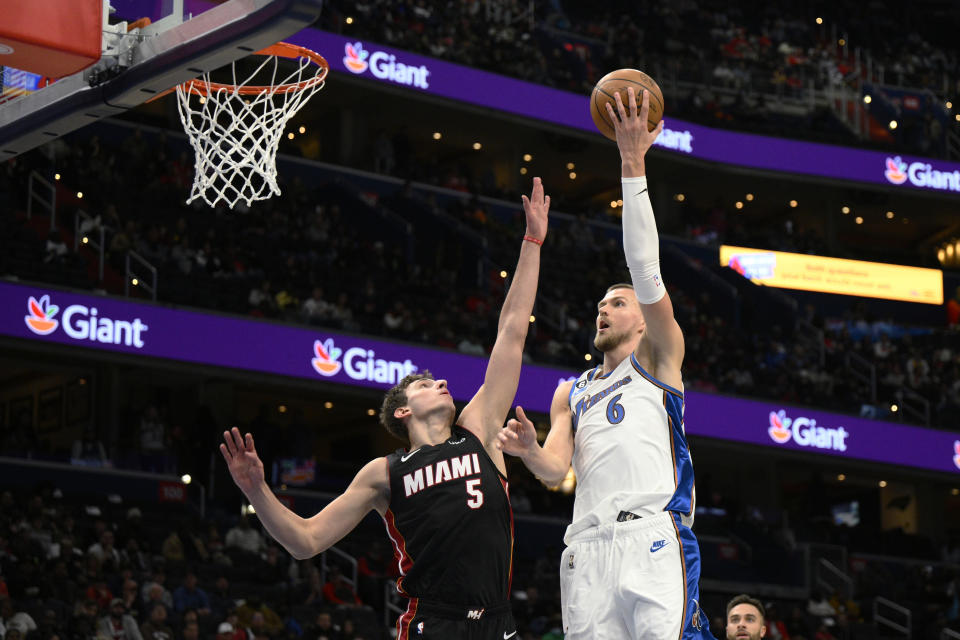 Washington Wizards center Kristaps Porzingis (6) goes to the basket against Miami Heat forward Nikola Jovic (5) during the first half of an NBA basketball game Friday, Nov. 18, 2022, in Washington. (AP Photo/Nick Wass)