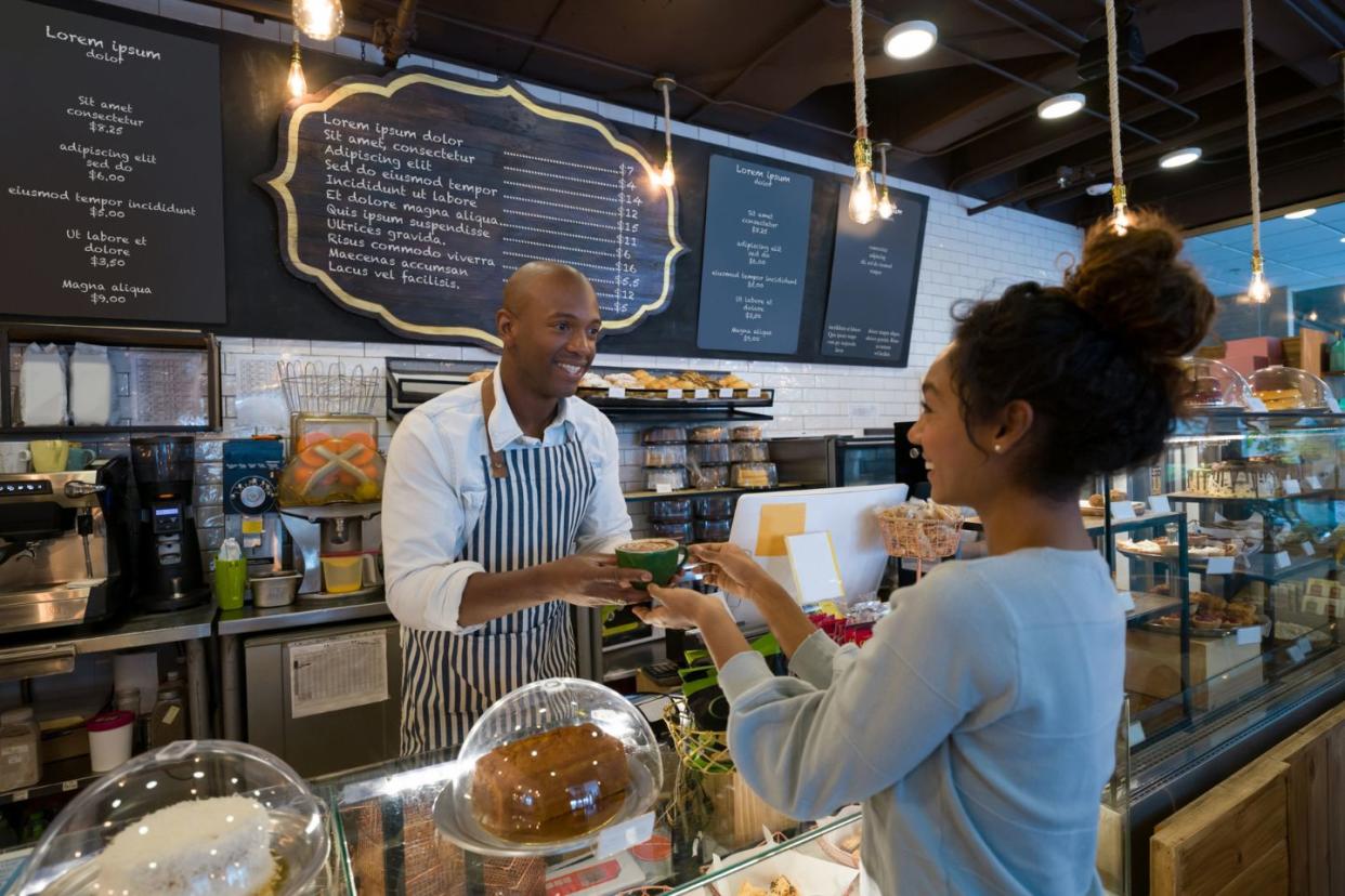 Black owned vegan restaurant owner with customer