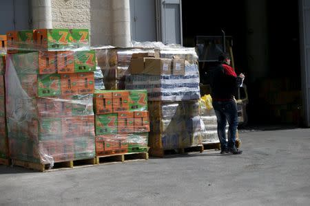 A man stands next to juice bottles produced by Israeli food-maker Tapuzina (L) outside a store in the West Bank city of Ramallah March 22, 2016. REUTERS/Mohamad Torokman