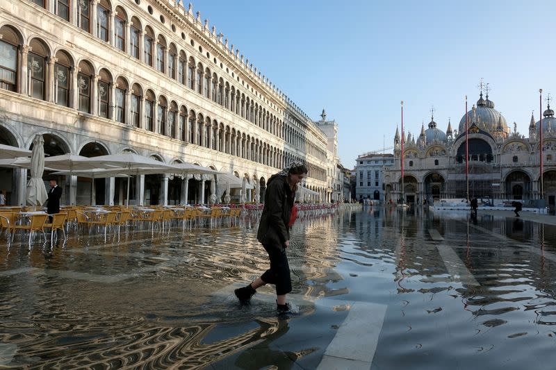 FILE PHOTO: A woman wades through water in flooded St. Mark's Square during seasonal high water in Venice