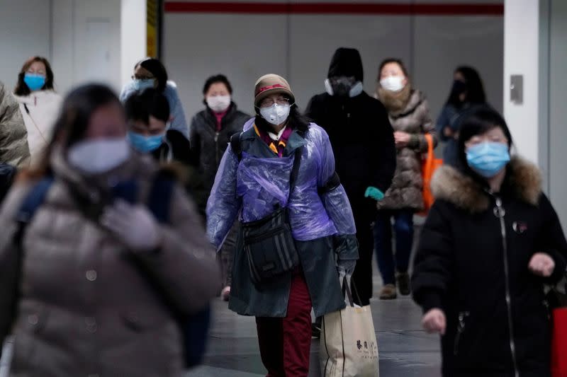 Personas con máscaras faciales caminan por una estación de metro en Shanghái