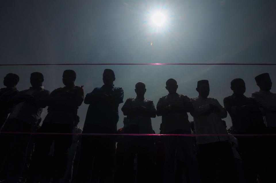 People pray for the eclipse during a rare "ring of fire" solar eclipse in Siak, Riau province on Dec. 26, 2019.