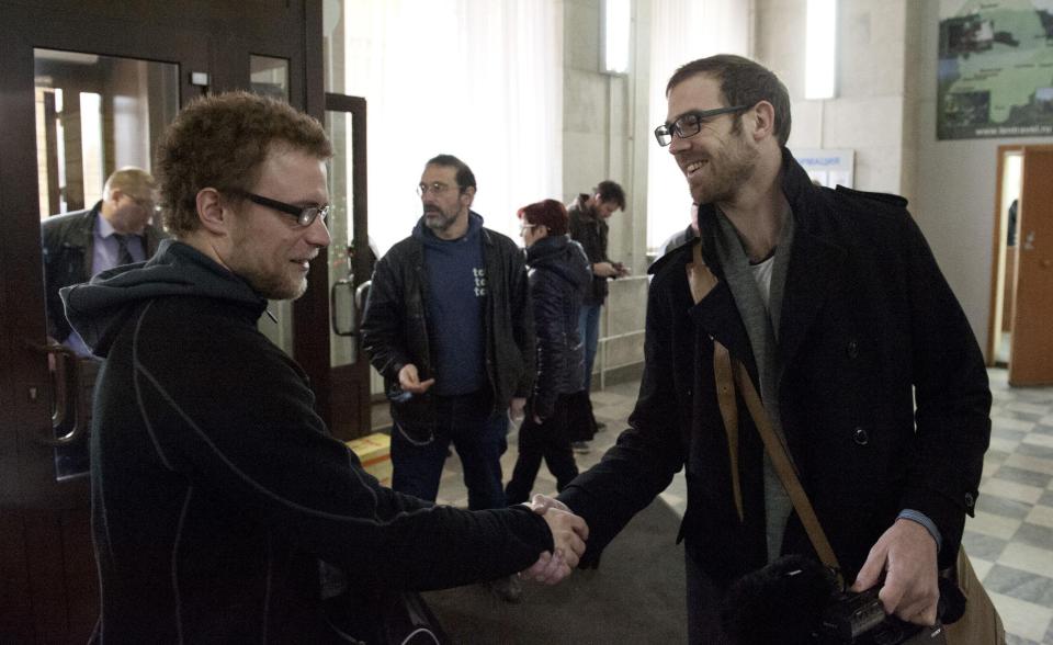 Greenpeace handout shows Greenpeace International activists Weber and videographer Bryan congratulating each other, after having criminal charges against them dropped, in Saint Petersburg