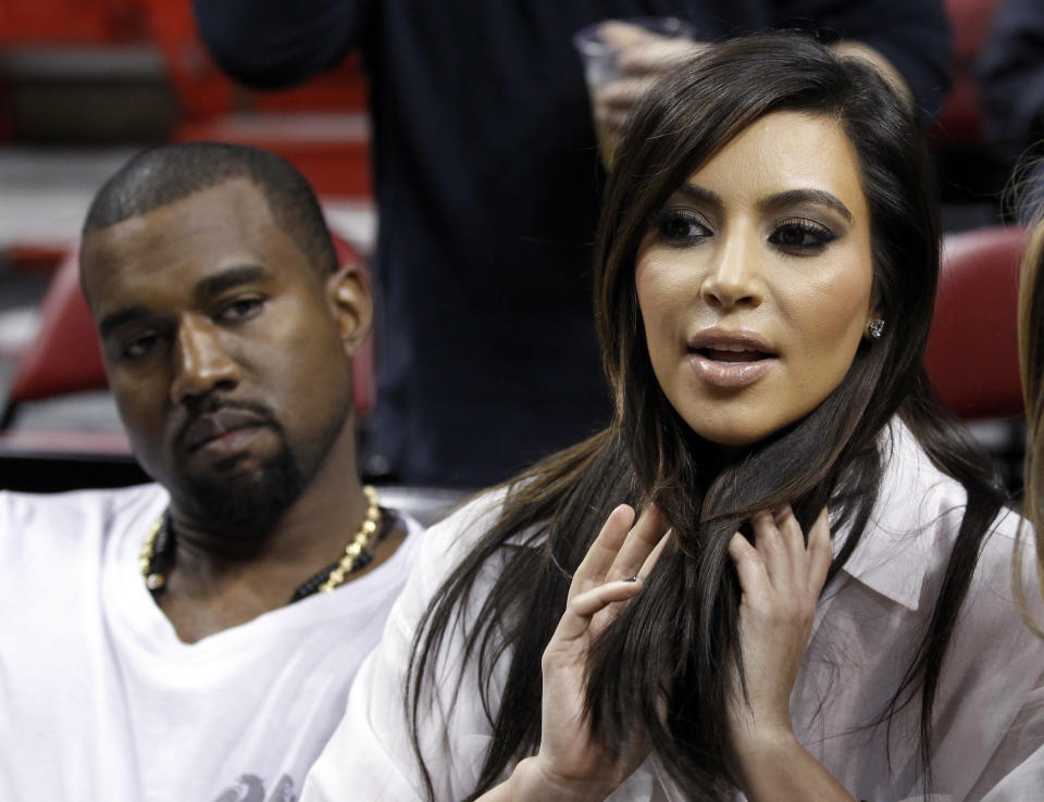 FILE - Kim Kardashian, right, and Kanye West, left, are shown before an NBA basketball game between the Miami Heat and the New York Knicks in this Dec, 6, 2012 file photo taken in Miami. The rapper Kanye West announced at a concert Sunday night Dec. 30, 2012 that his girlfriend is pregnant. He told the crowd of more than 5,000 at the Ovation Hall at the Revel Resort in song form: "Now you having my baby." ( AP Photo/Alan Diaz, File)