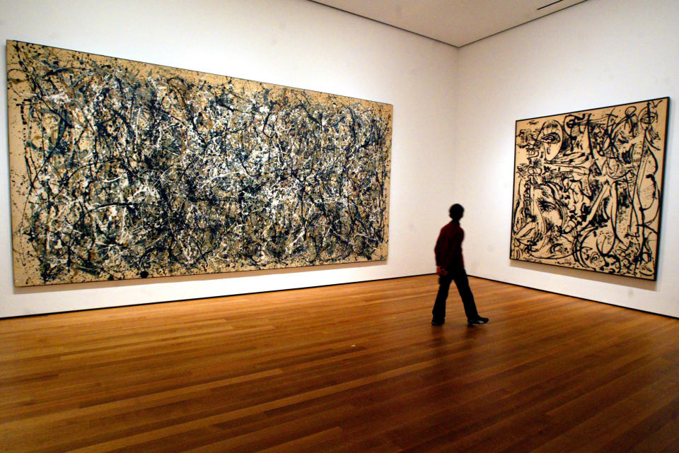 FILE - In this April, 13, 2005 file photo, a visitor strolls by canvasses by Abstract Expressionist Jackson Pollock at the Museum of Modern Art in New York. Pollock, who would have turned 100 in 2012, will have the anniversary of his birth observed with exhibitions, fundraisers and other events throughout the year.  (AP Photo/Mary Altaffer, File)