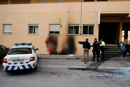 The police officers are seen near the damage caused by molotov cocktails is seen on the police station building at the Bela Vista neighborhood in Setubal, Portugal January 22, 2019. REUTERS/Rafael Marchante