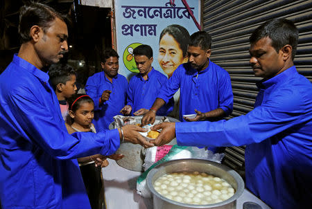 Trinamool Congress (TMC) party workers distribute sweets to the residents during a mass marriage organized by party workers in Kolkata, February 9, 2019. REUTERS/Rupak De Chowdhuri/Files