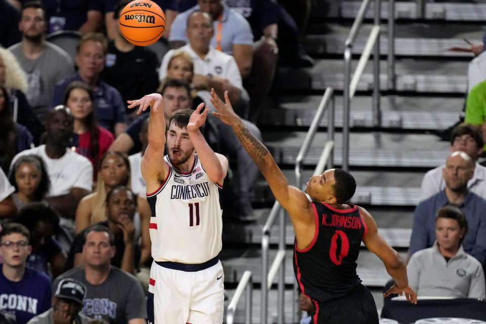 Connecticut forward Alex Karaban shoots past San Diego State forward Keshad Johnson during the second half of the men's national championship college basketball game in the NCAA Tournament on Monday, April 3, 2023, in Houston.