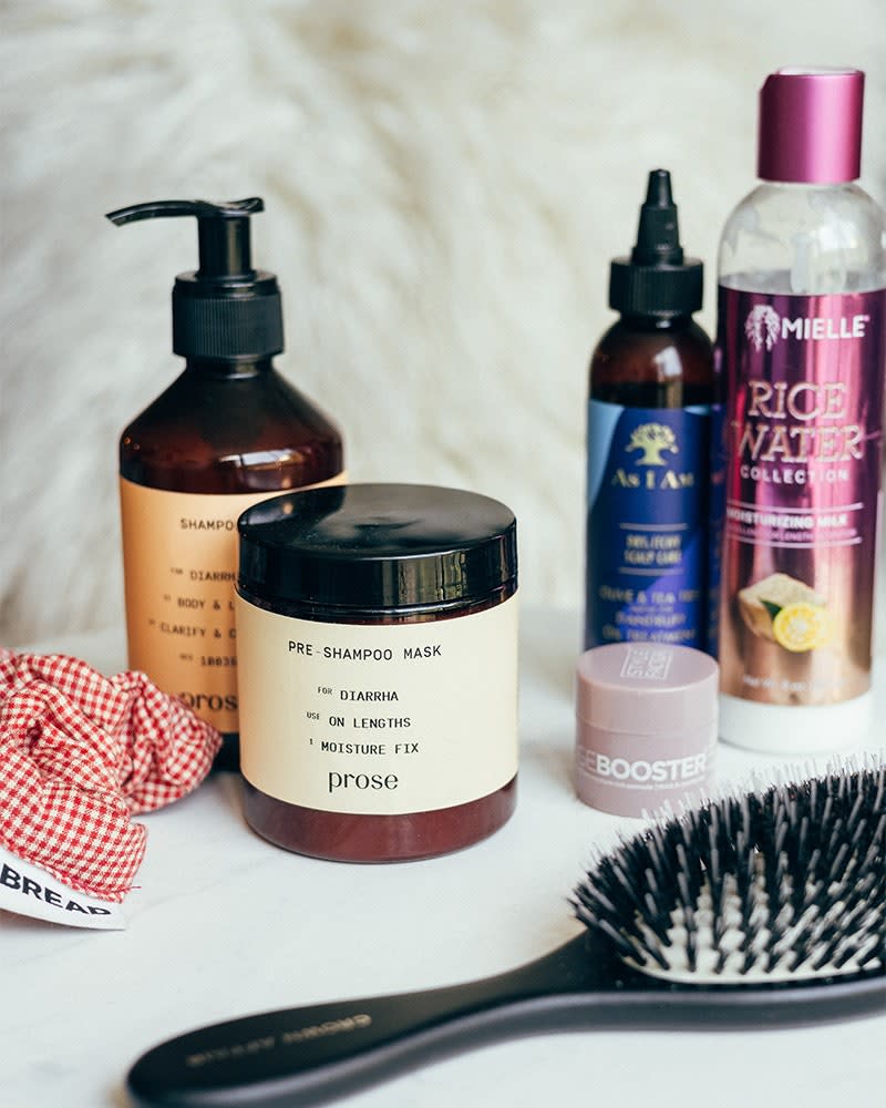 “My go to hair products! Featured here is my fave Bread Beauty Supply scrunchie, Prose, Mielle Organics, Edge Booster, As I Am and Crown Affair The Brush No 003.”