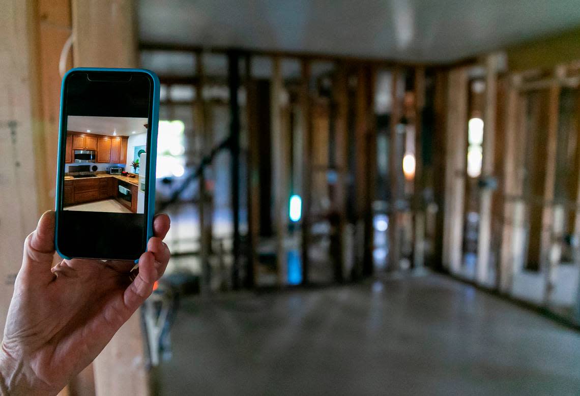 Jennifer, 65, shows a photo of her kitchen before Hurricane Ian destroyed it while giving a tour of her damaged home on Tuesday, Oct. 18, 2022, in Bonita Shores.