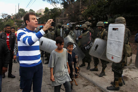 Opposition candidate Salvador Nasralla, films with a mobile phone soldiers during a protest against the re-election of Honduras' President Juan Orlando Hernandez in Tegucigalpa, Honduras January 20, 2018. REUTERS/Jorge Cabrera