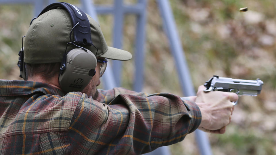 A shooter fires a handgun at a target at Slate Ridge Vermont, an un-permitted gun range and firearms training center owned by Daniel Banyai, Saturday April 17, 2021 in West Pawlet, Vt., during what organizers called a Second Amendment Day Picnic. Banyai has until summer to remove all unpermitted structures at a gun training center, which was built without zoning approval, after a ruling by the Vermont Environmental Court. The court is fining Banyai $200 a day and ruled Wednesday Feb. 9, 2023 that he would be jailed if he does not comply with orders by the end of June. (AP Photo/Wilson Ring, File)