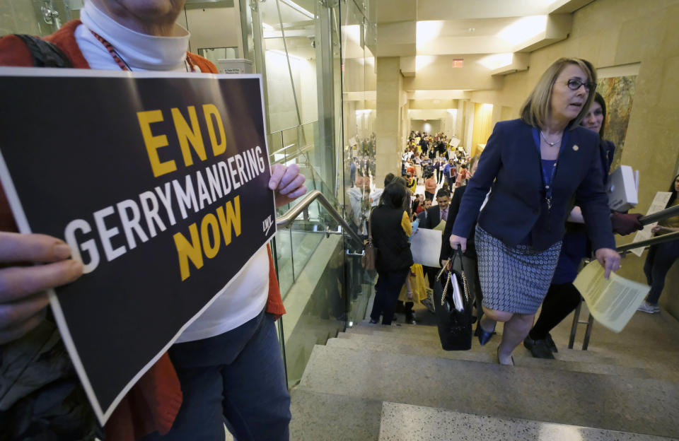 FILE - Del. Martha Mugler, D-Hampton, second from right, and Del. Danica Roem, D-Prince William, right, walk past a group of demonstrators as they head to the House of Delegates inside the Virginia state Capitol in Richmond, Va., on March 2, 2020. One of the two outstanding vote recounts requested by Mugler, of the 91st District, and Democratic Del. Alex Askew, who currently represents the 85th House District, that will settle whether Virginia Republicans have reclaimed the majority in the House of Delegates is set to get underway Thursday, Dec. 2, 2021, in Virginia Beach. (Bob Brown/Richmond Times-Dispatch via AP, File)