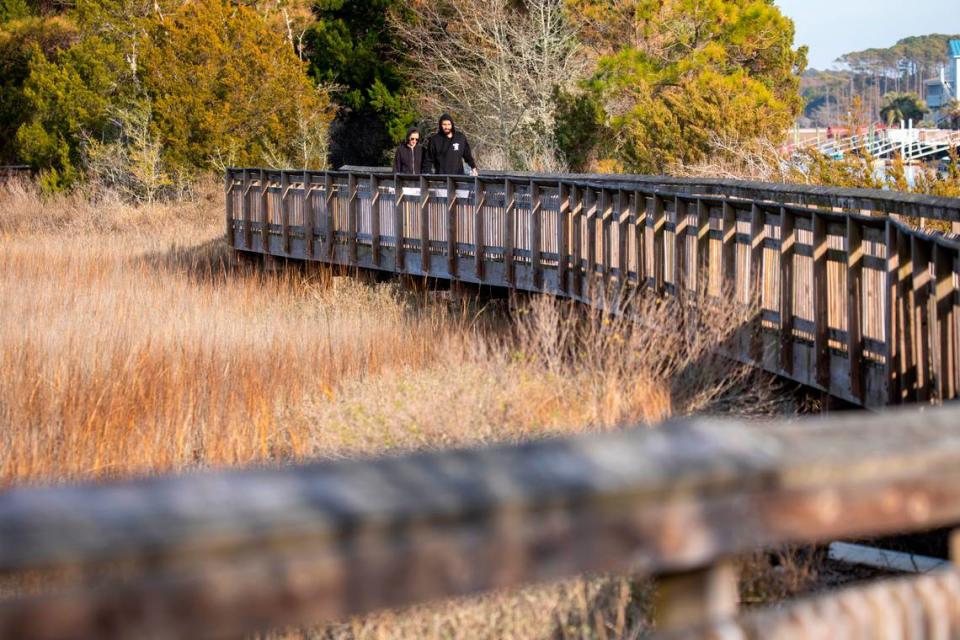 Visitors to the Heritage Shores Nature Preserve walk one of the elevated boardwalks over the marsh at Hog Inlet in North Myrtle Beach on January 11, 2023.