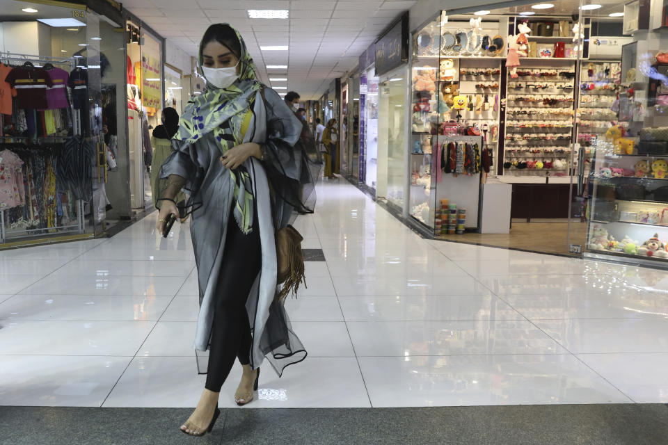 A woman wearing a protective face mask to help prevent the spread of the coronavirus walks through the Nasr Shopping Center in Tehran, Iran, Wednesday, July 15, 2020.Iran's President Hassan Rouhani has said lockdowns over COVID-19 pandemic may lead to street protests over economic problems, though in Tehran, authorities have decided to impose some restrictions again over newly spiking reported deaths from the coronavirus. (AP Photo/Vahid Salemi)