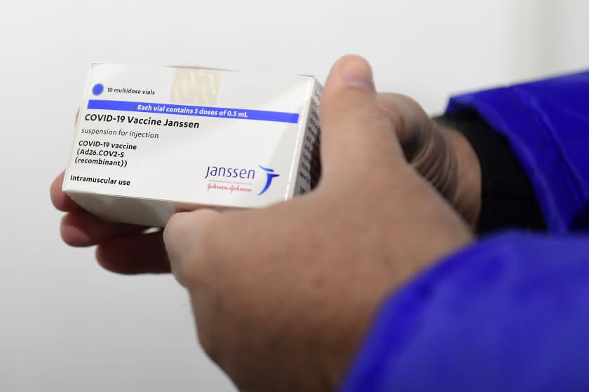 A pharmacist holds a box of Johnson & Johnson vaccines.