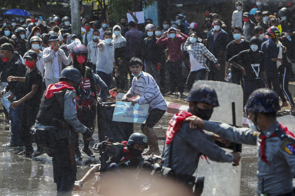 FILE - Protesters run after police shot warning shots and used water cannon to disperse them during a protest in Mandalay, Myanmar on Feb. 9, 2021. A human rights group and 16 people from Myanmar have filed a criminal complaint in Germany seeking punishment of Myanmar's generals for genocide, war crimes and crimes against humanity they alleged were committed in that country after their 2021 government takeover and during a 2017 crackdown on Muslim Rohingya. (AP Photo, File)