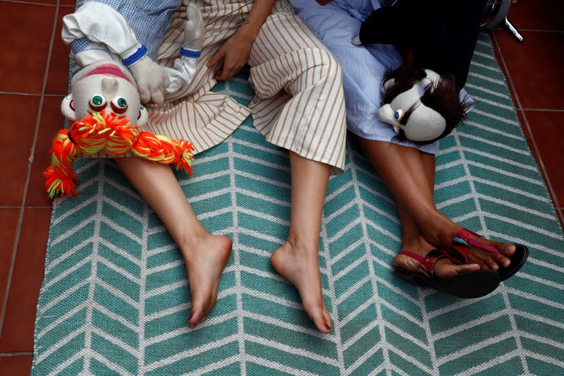 Actress and puppeteer Yohana Yara and her colleague Alicia Lorente take a break from filming their puppet show at her home in Madrid