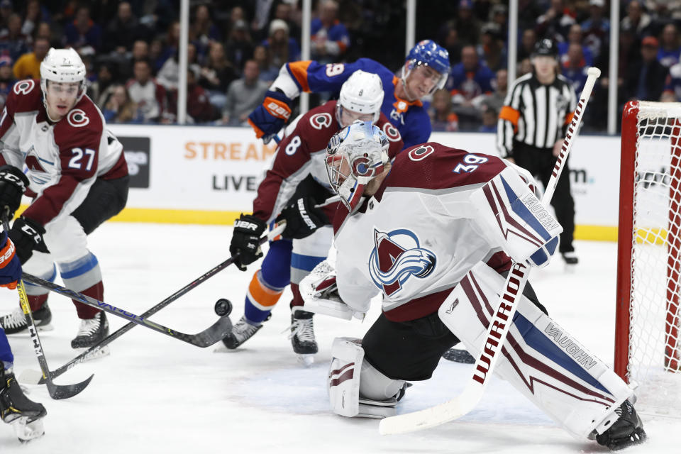 Colorado Avalanche goaltender Pavel Francouz (39) keeps his eye on the puck as it bounces off the stick of an Islanders player during the second period of an NHL hockey game, Monday, Jan. 6, 2020, in Uniondale, N.Y. (AP Photo/Kathy Willens)