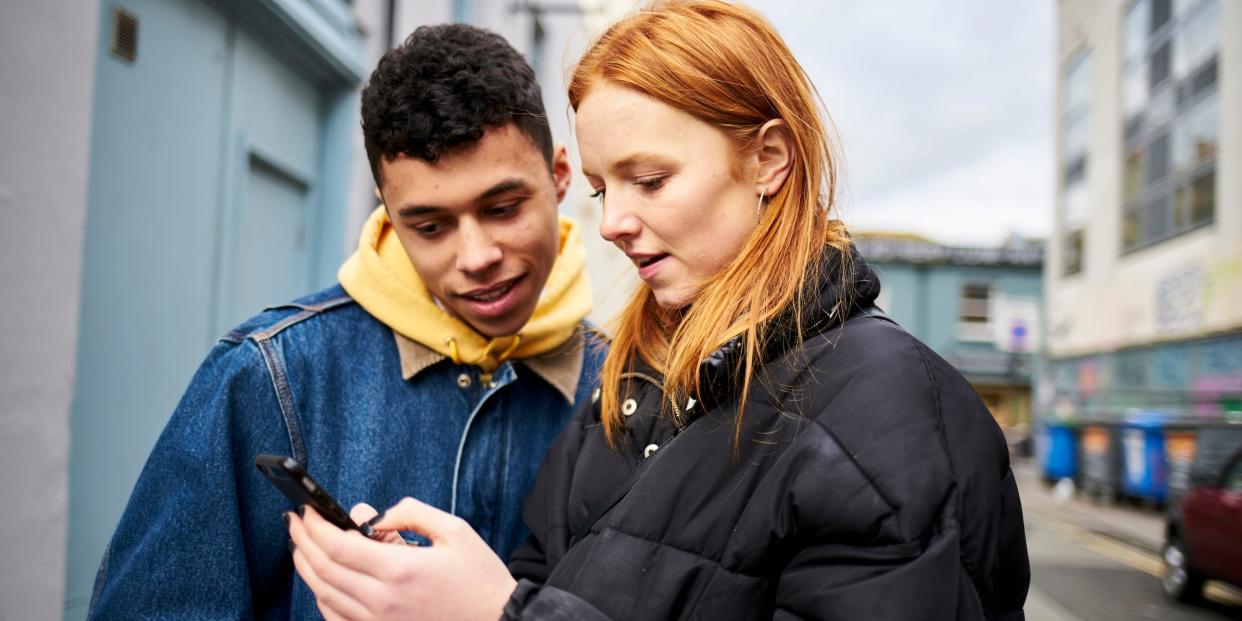 couple looking at smartphone outside