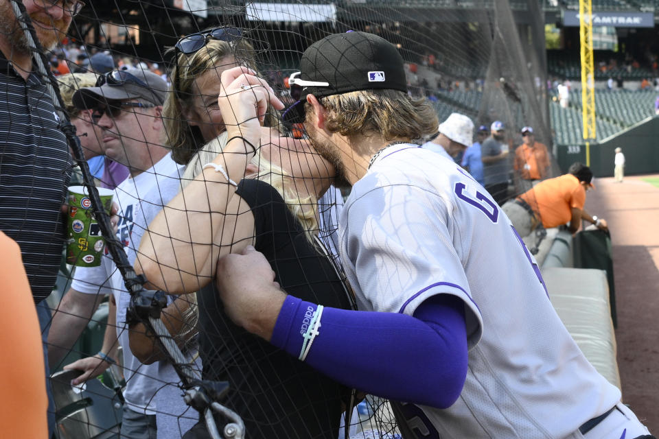 Colorado Rockies' Hunter Goodman, right, gets a kiss from his fiancee Sydney McClain after a baseball game against the Baltimore Orioles, Sunday, Aug. 27, 2023, in Baltimore. The Rockies won 4-3. (AP Photo/Nick Wass)