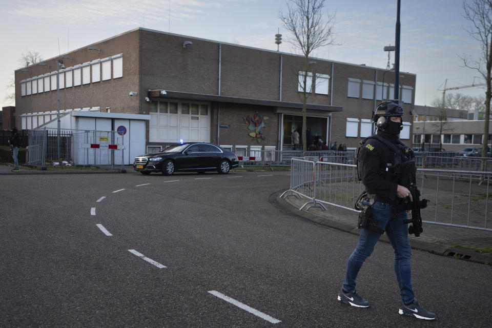 Masked and armed Dutch police guard a transport of some of the suspects who arrived at the high security court building where the trial opened in Amsterdam, Netherlands, Tuesday, Jan. 23, 2024, for suspects in the slaying of campaigning Dutch journalist Peter R. De Vries. A long-delayed trial opened Tuesday of nine men accused of involvement in the fatal shooting on a downtown Amsterdam street of Dutch investigative reporter de Vries. (AP Photo/Peter Dejong)