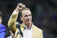 Former Indianapolis Colts player Peyton Manning holds up his Pro Football Hall of Fame commemorative ring during an NFL football game, Sunday, Sept. 19, 2021, in Indianapolis.(AP Photo/Michael Conroy)