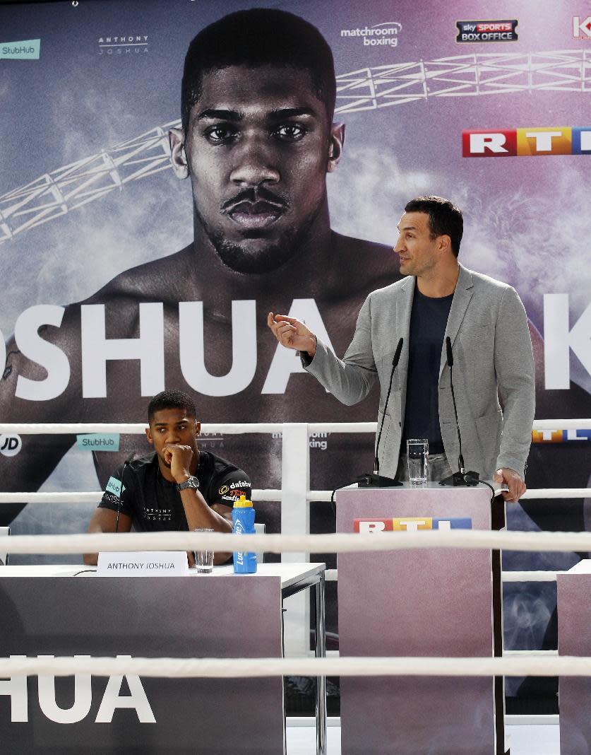 Ukrainian boxer Wladimir Klitschko, right, and Britain's Anthony Joshua face each other during a press conference in Cologne, western Germany, Thursday, Feb. 16, 2017. Klitschko and Joshua will fight for the IBF title in London on April 29. (Roland Weihrauch/dpa via AP)