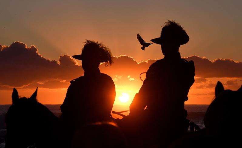 Horsemen stay on their mounts during the Anzac Day Dawn Service held by the Currumbin RSL is seen at Elephant Rock on Currumbin Beach, Gold Coast. Source: AAP