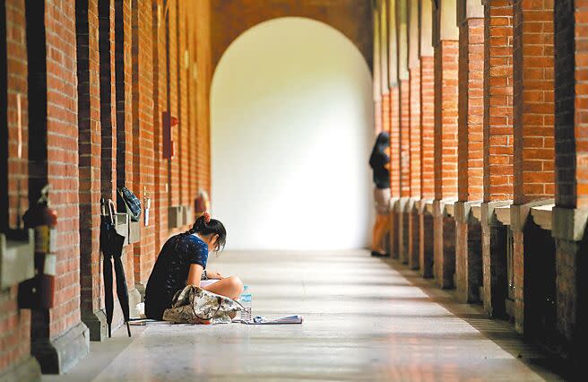 少子化猛烈衝擊，近年許多大學招不到學生面臨退場。圖為一名考生坐在走廊專心準備大考，比起以往考場的熱鬧景象，顯得冷清不少。（本報資料照片）