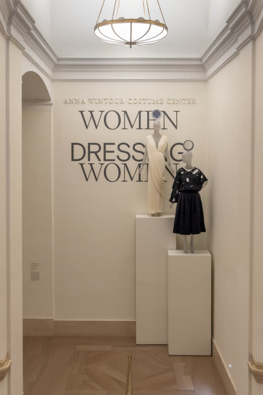 The title wall of "Women Dressing Women," featuring a Madame Grès dress (ca. 1965) and a Fall 1982 Comme des Garçons ensemble.<p>Photo: Courtesy of the Metropolitan Museum of Art</p>