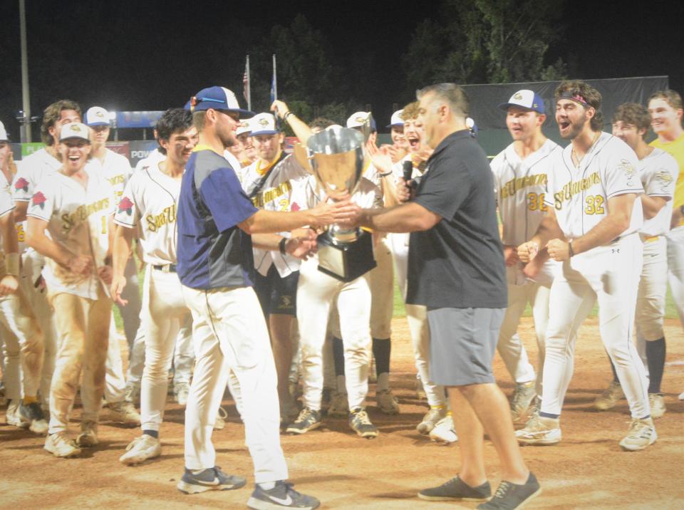 Futures League Commissioner Joe Paolucci hands the championship trophy to Norwich Sea Unicorns manager Kevin Murphy. The Sea Unicorns defeated the Vermont Lake Monsters, 2-1, in a winner-take-all final Sunday night at Dodd Stadium.