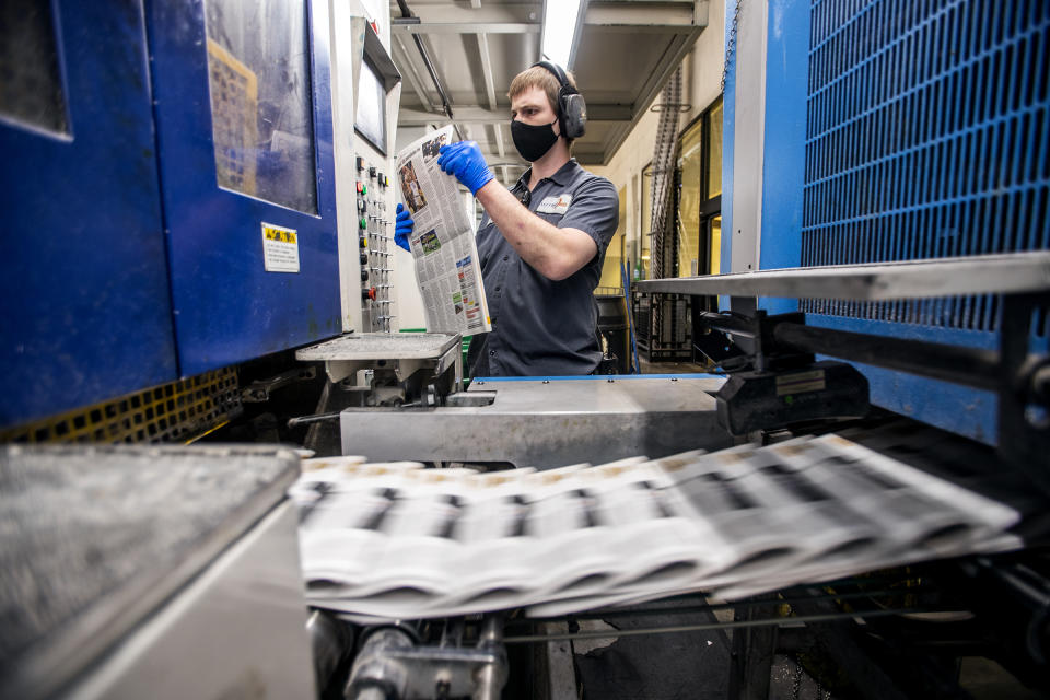 A press worker checks a newspaper as the last daily edition of the Deseret News is printed at the MediaOne building in West Valley City, Utah, on Wednesday, Dec. 30, 2020. Both of Salt Lake City's major newspapers released their final daily print editions Thursday as the two publications transition to weekly editions. The Salt Lake Tribune, which won the Pulitzer Prize for local reporting in 2017, will continue to publish breaking stories online every day. The 170-year-old Deseret News in the state capital will also shift its attention online and offer a monthly magazine which will debut in January. (Scott G Winterton/The Deseret News via AP)