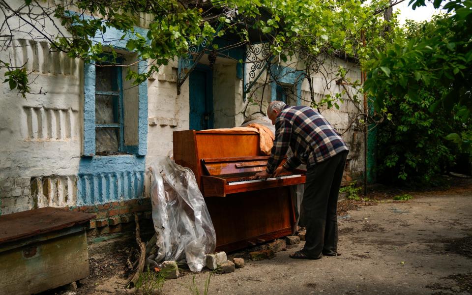 A local resident plays the piano outside a destroyed building in eastern Ukraine. Civilians are fleeing from the Donbas area, which is now the centre of fighting, in their droves - Francisco Seco 