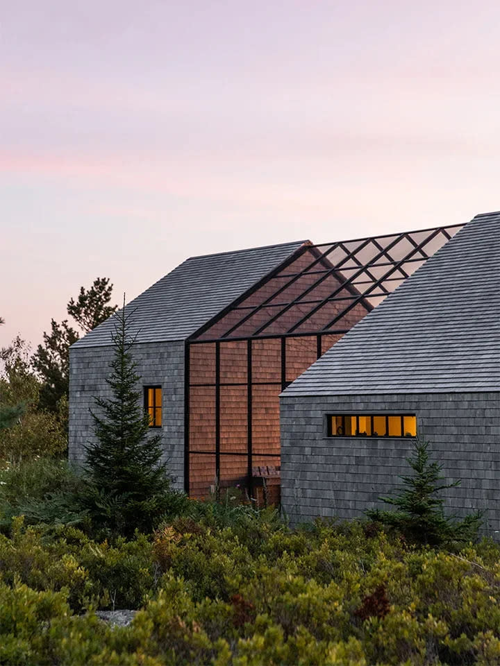 House in nature with giant screened-in porch connecting two buildings.