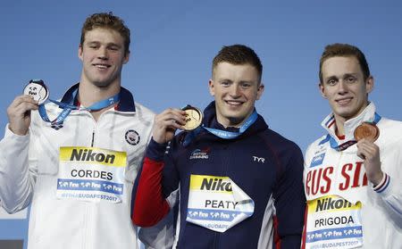 Swimming – 17th FINA World Aquatics Championships – Men's 100m Breaststroke awarding ceremony – Budapest, Hungary – July 24, 2017 – Kevin Cordes of the U.S. (silver), Adam Peaty of Britain (gold) and Kirill Prigoda of Russia (bronze) pose with the medals. REUTERS/Bernadett Szabo