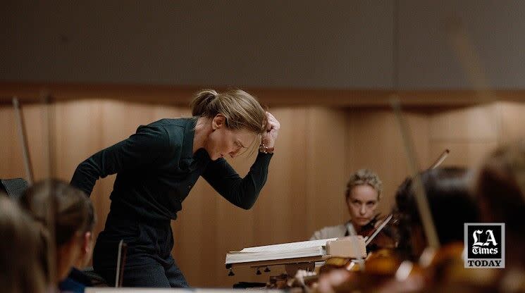A female conductor moves her arms during an orchestra rehearsal in a scene from the movie "Tár."