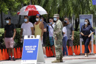 People wait in line at a walk-up testing site for COVID-19 during the new coronavirus pandemic, Tuesday, June 30, 2020, in Miami Beach, Fla. (AP Photo/Lynne Sladky)