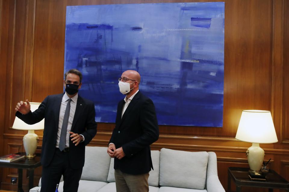 Greece's Prime Minister Kyriakos Mitsotakis, left, speaks with European Council President Charles Michel during their meeting at Maximos Mansion in Athens, Tuesday, Sept. 15, 2020. Michel will visit Lesbos later today as Greece's migration minister says the government will use force if necessary to move homeless migrants to a new facility on the island after thousands of people were left without shelter by fires last week at an overcrowded refugee camp. (AP Photo/Thanassis Stavrakis)