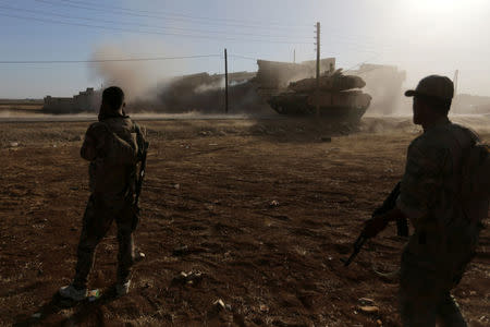 A rebel fighter covers his ears near a Turkish tank after it fired towards Guzhe village, northern Aleppo countryside, Syria October 17, 2016. REUTERS/Khalil Ashawi