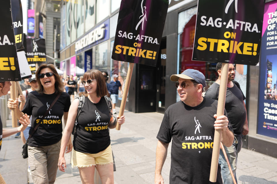 ARCHIVO - Los actores Jennifer Van Dyck, a la izquierda, y Jason Kravits, a la derecha, llevan carteles en un mitin frente a Paramount en Times Square en Nueva York el lunes 17 de julio de 2023. (Foto Charles Sykes/Invision/AP, archivo)