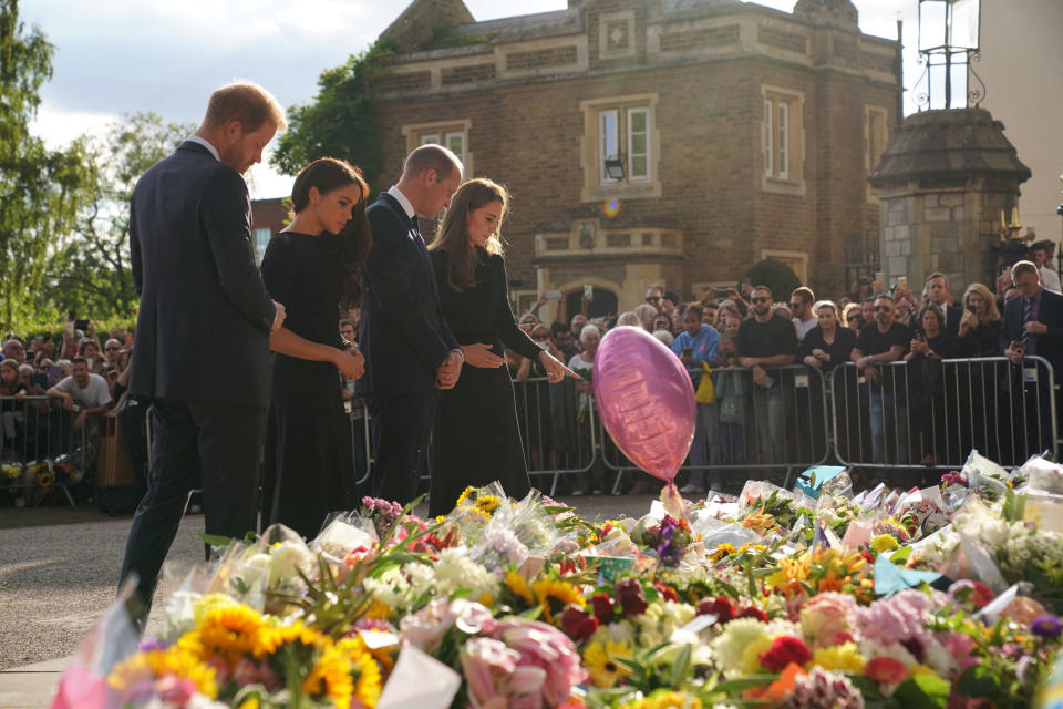 Britain's William, Prince of Wales, Catherine, Princess of Wales, Britain's Prince Harry and Meghan, the Duchess of Sussex, look at floral tributes laid by members of the public at Windsor Castle, following the passing of Britain's Queen Elizabeth, in Windsor, Britain, September 10, 2022. Kirsty O'Connor/PA Wire/Pool via REUTERS