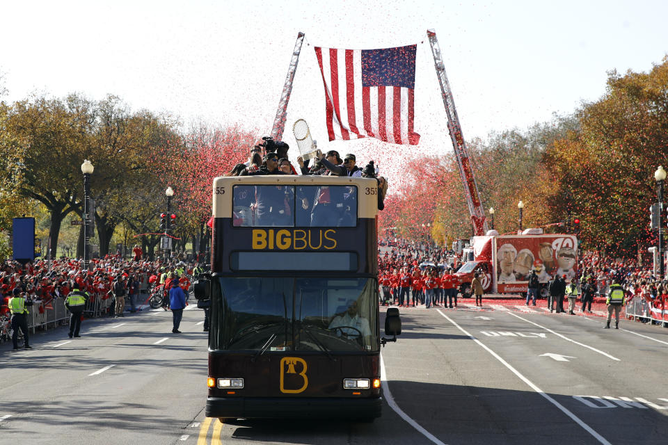 Fans cheer as a bus carrying the Washington Nationals' World Series trophy drives by during a parade to celebrate the team's World Series baseball championship over the Houston Astros, Saturday, Nov. 2, 2019, in Washington. (AP Photo/Patrick Semansky)