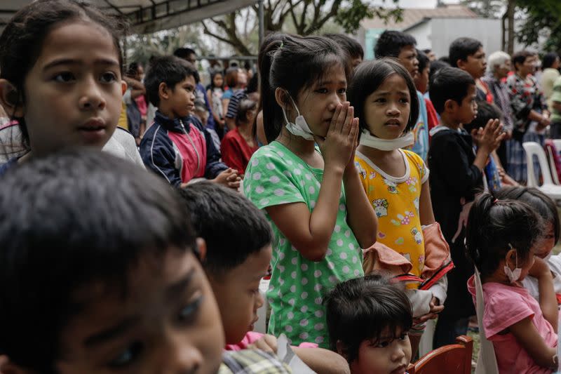 Children displaced by the erupting Taal Volcano attend a Catholic mass in an evacuation center, in Tagaytay City,