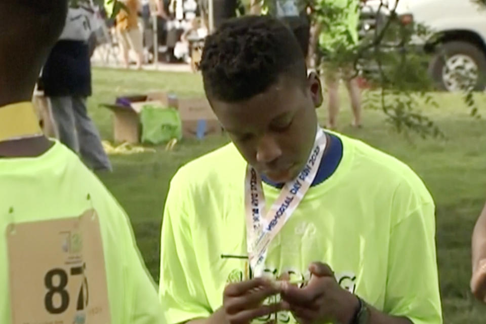 FILE - Ralph Yarl looks at a badge that he received after walking at a brain injury awareness event, May 29, 2023, in Kansas City, Mo. The family of Yarl, a Black teenager who was shot when he mistakenly went to the wrong home in Kansas City, Mo., filed a lawsuit Monday, April 29, 2024, against the white 84-year-old homeowner, an attempt to pursue justice from the “driver’s seat” and put pressure on the criminal trial scheduled for later this year, the family's attorney said. (KCTV via AP, File)