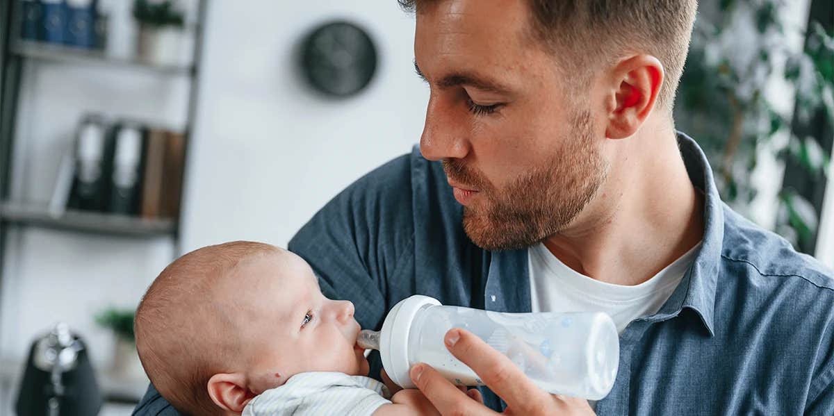 man bottle feeding baby