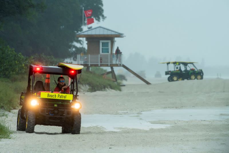 Lifeguards patrol the shore under double red flags after closing the beach to swimmers before the arrival of Tropical Storm Eta in Bradenton Beach