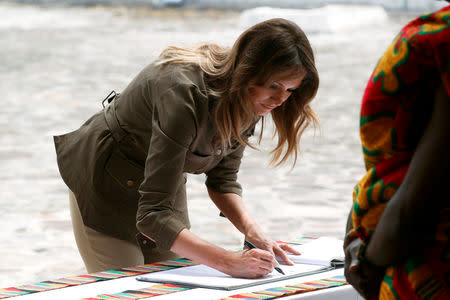 U.S. first lady Melania Trump signs a visitors book during a visit to Cape Coast castle, Ghana, October 3, 2018. REUTERS/Carlo Allegri